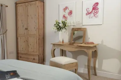 a bedroom with a dressing table and a mirror at School Cottage, Marazion in Marazion