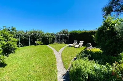 a path in the middle of a field with chairs at Rivermead Beach House -Modern beach house with indoor pool in Treknow