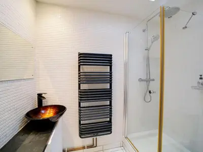 a bathroom with a sink and a bath tub at Rivermead Beach House -Modern beach house with indoor pool in Treknow