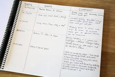 a notebook with handwriting on it on a table at Rivermead Beach House -Modern beach house with indoor pool in Treknow