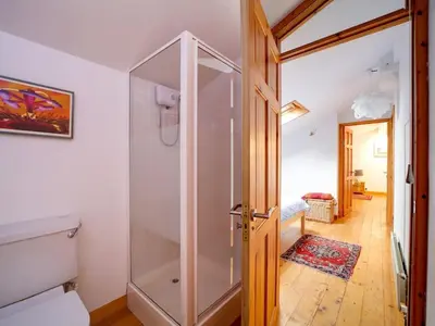 a bathroom with a shower and a glass door at Rivermead Beach House -Modern beach house with indoor pool in Treknow