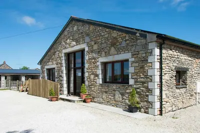 a stone house with potted plants in front of it at Trippet Cottage in Saint Breward