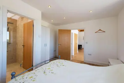 a bedroom with a bed and a walk in shower at Trippet Cottage in Saint Breward