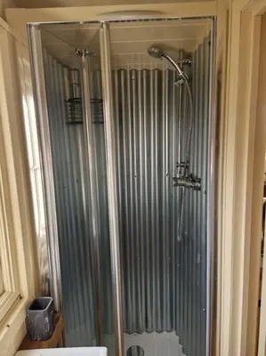 a glass shower in a bathroom with a toilet at Shepherds haven hut Near Padstow in Saint Issey