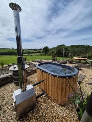 a hot tub in the middle of a yard at Shepherds haven hut Near Padstow in Saint Issey