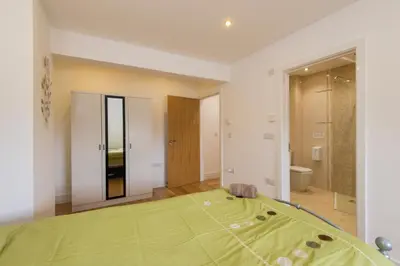 a bedroom with a green bed and a bathroom at Jubilee Cottage - Cwc75016 in Saint Breward