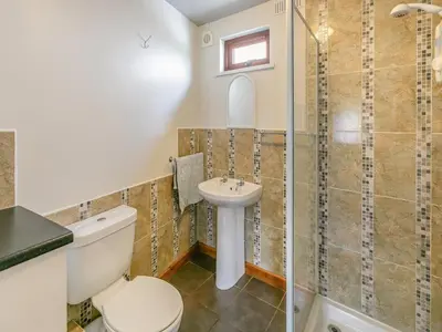 a bathroom with a toilet and a shower and a sink at Contention Barn in Perranporth