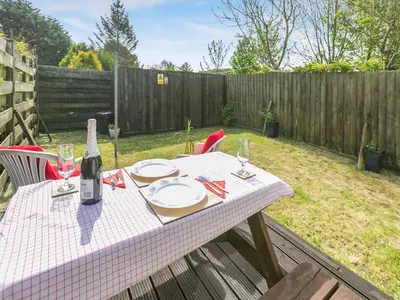 a picnic table with a bottle of wine and glasses at Contention Barn in Perranporth