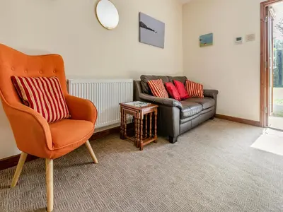 a living room with a chair and a couch at Contention Barn in Perranporth