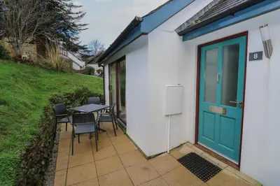 a patio with a blue door and a table and chairs at Villa Gallery in Truro