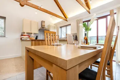 a kitchen and dining room with a wooden table and chairs at Villa Gallery in Truro