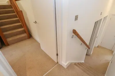 a hallway with a staircase with a door and a stair railing at Villa Gallery in Truro