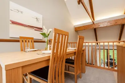a dining room with a wooden table and chairs at Villa Gallery in Truro