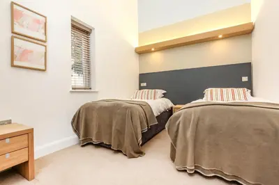 a bedroom with two beds and a dresser at Villa Gallery in Truro
