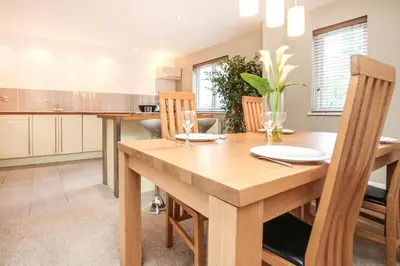 a kitchen with a wooden dining room table and chairs at Haven in Truro