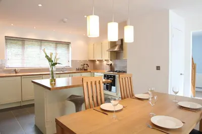 a kitchen with a wooden table with two chairs and a dining room at Haven in Truro