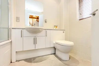 a white bathroom with a sink and a toilet at Haven in Truro