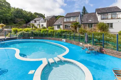 a large swimming pool with a table and chairs at Haven in Truro