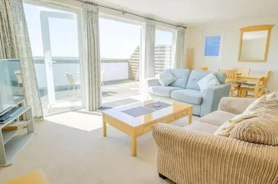 a living room with a couch and a table at Flat 2 Mawgan Porth Golf Club in Mawgan Porth