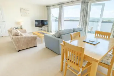a living room with a table and a couch at Flat 2 Mawgan Porth Golf Club in Mawgan Porth