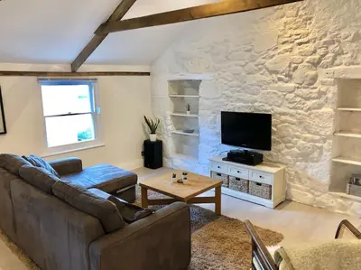 a living room with a couch and a tv at The Loft - Bright apartment centre St Ives sleep 4 in St Ives