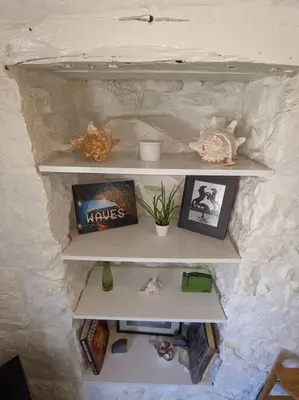 a shelf in a wall with pictures on it at The Loft - Bright apartment centre St Ives sleep 4 in St Ives