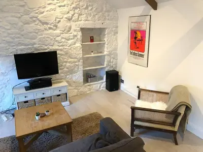 a living room with a tv and a couch at The Loft - Bright apartment centre St Ives sleep 4 in St Ives