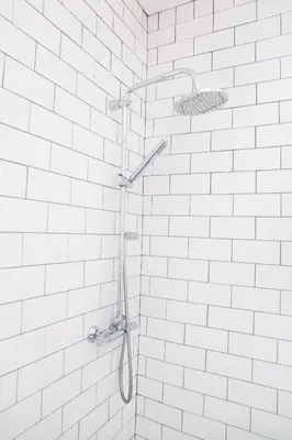 a shower in a bathroom with white tiles at The Lerryn in Falmouth