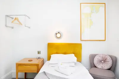 a bedroom with a bed and a chair at The Lerryn in Falmouth