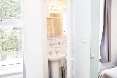 a white bathroom with a sink and a window at The Lerryn in Falmouth
