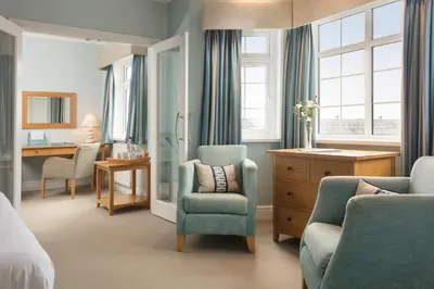 a bedroom with a bed and a chair and a desk at St Michaels Resort, Falmouth in Falmouth