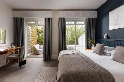 a bedroom with a bed and a desk and windows at St Michaels Resort, Falmouth in Falmouth