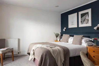 a bedroom with a bed and a blue wall at St Michaels Resort, Falmouth in Falmouth