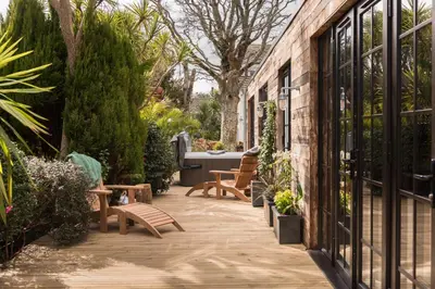a patio with benches and plants in a garden at Merchants Manor Spa in Falmouth