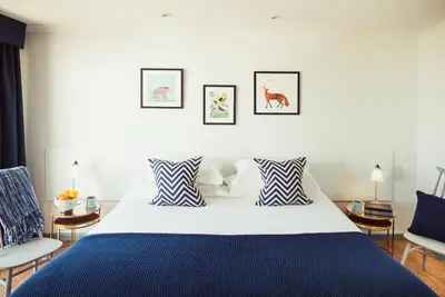 a bedroom with a blue and white bed and two chairs at Merchants Manor Spa in Falmouth