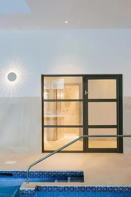 a room with a swimming pool and a glass door at Merchants Manor Spa in Falmouth