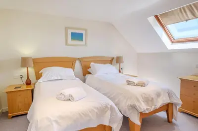 two beds in a room with towels on them at Flat 3 Mawgan Porth Golf Club in Mawgan Porth