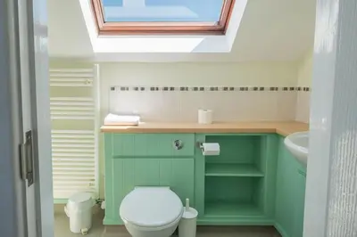 a bathroom with a toilet and a sink and a window at Flat 3 Mawgan Porth Golf Club in Mawgan Porth