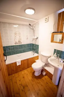 a bathroom with a toilet and a tub and a sink at Treworgie Barton - Myll in Bude