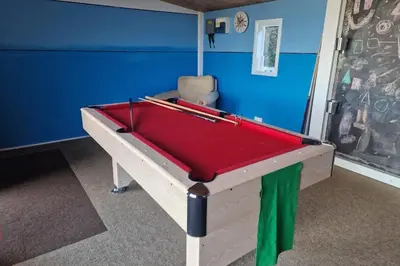 a red pool table in a room with a chair at Treworgie Barton - Myll in Bude