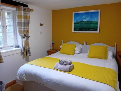 a bedroom with a bed with a towel on it at The Barn in Penzance