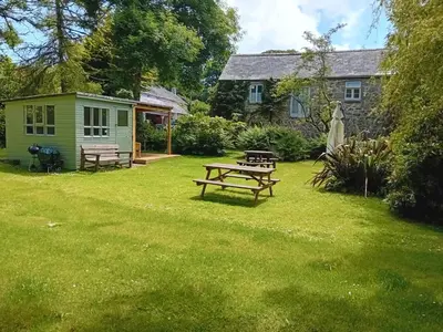 a picnic table in the yard of a cottage at The Barn in Penzance