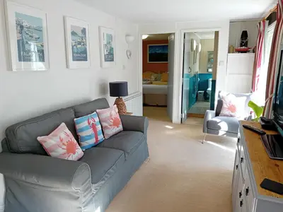 a living room with a gray couch with pillows at The Barn in Penzance