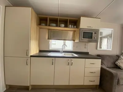 a small kitchen with a sink and a microwave at 11 Meadow View in Newquay