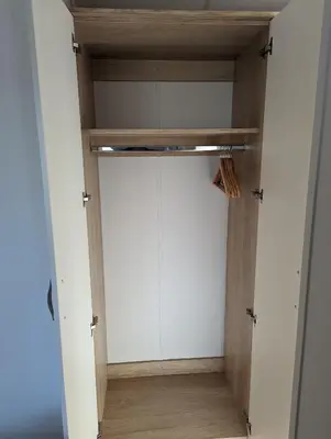 a closet with white cabinets and a wooden floor at 11 Meadow View in Newquay