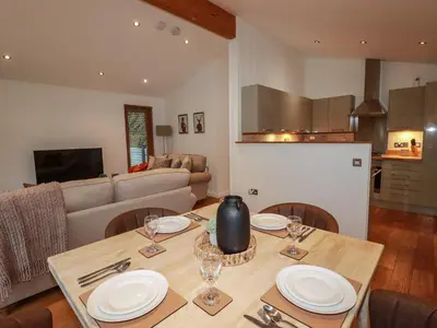a living room with a table with plates and wine glasses at 1 Streamside in Looe