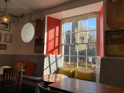 a restaurant with a window with a view of a church at St Agnes Hotel in St. Agnes