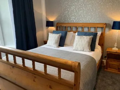 a bedroom with a wooden bed with blue and white pillows at St Agnes Hotel in St. Agnes