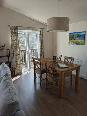 a living room with a table and a couch at Two Bedroom Lodge In The Country - Restaurant Bar Onsite in Liskeard