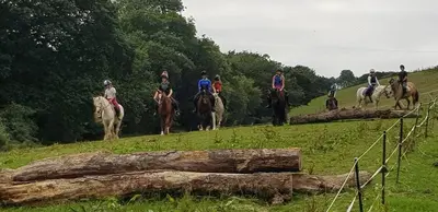 a group of people riding horses on a field at Two Bedroom Lodge In The Country - Restaurant Bar Onsite in Liskeard